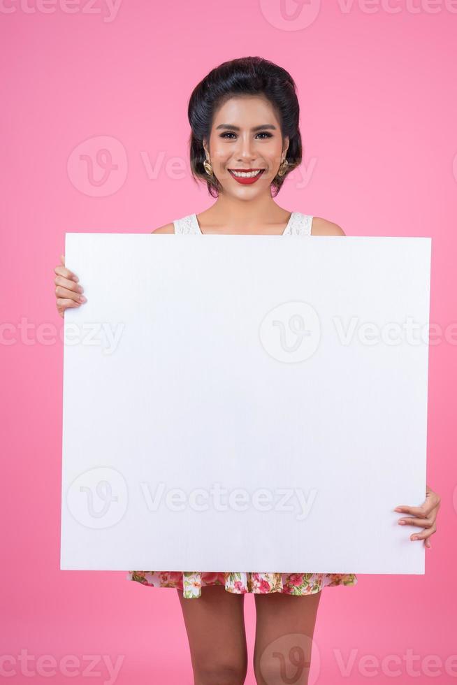 Retrato de una mujer de moda mostrando una pancarta blanca foto