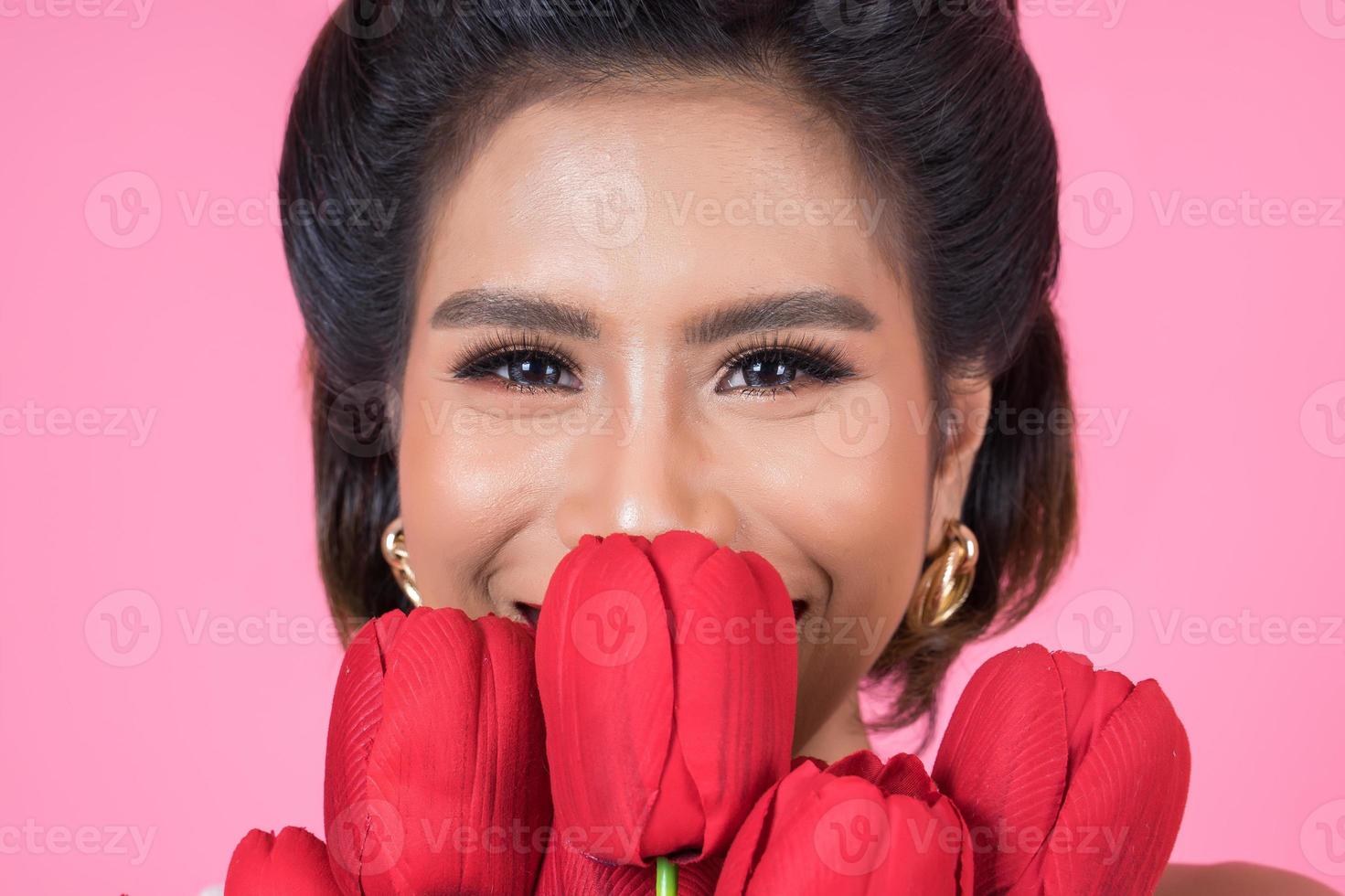 Portrait of a beautiful woman with bouquet of red tulip flowers photo