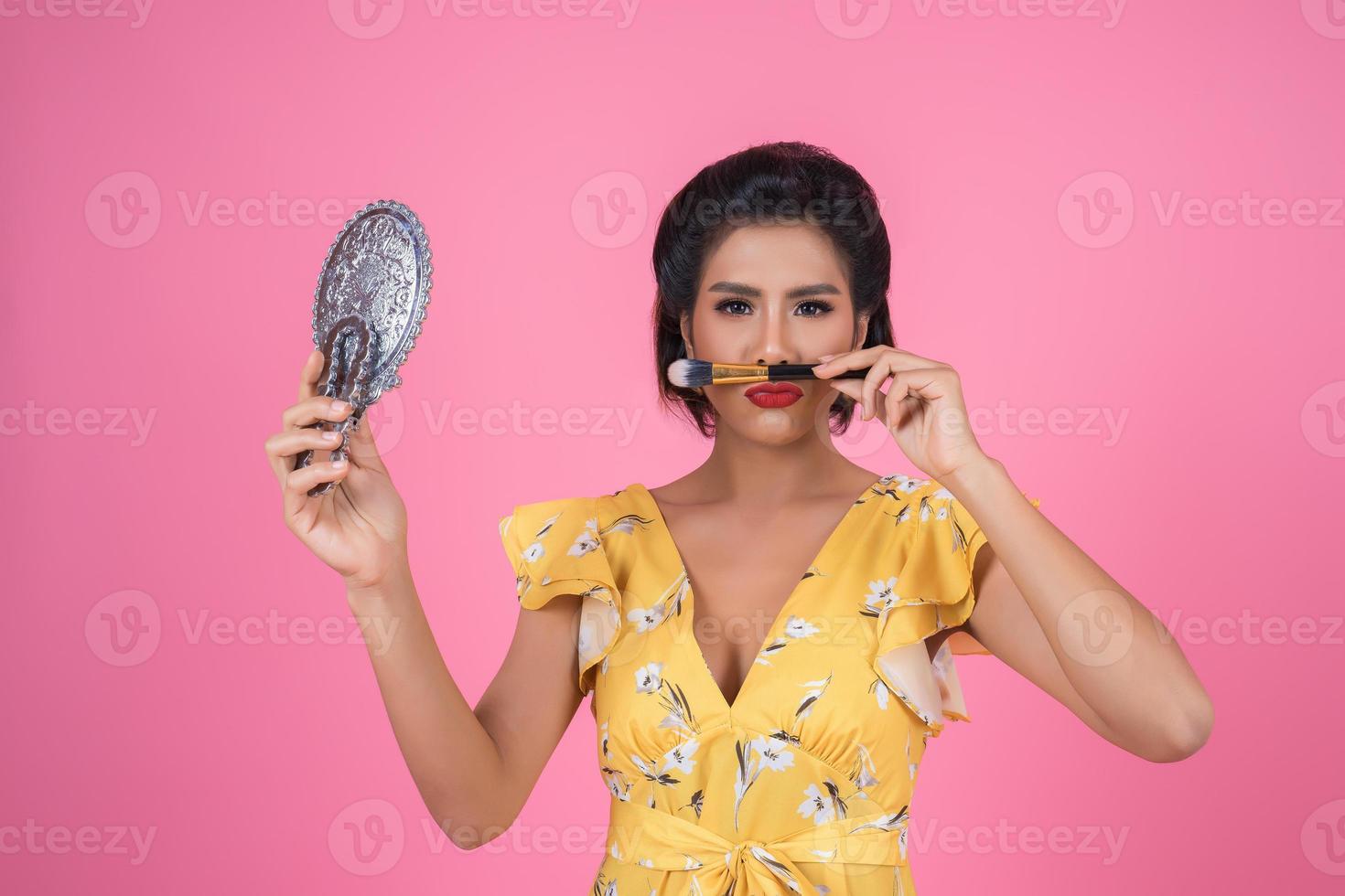 Fashionable woman with makeup and mirror photo