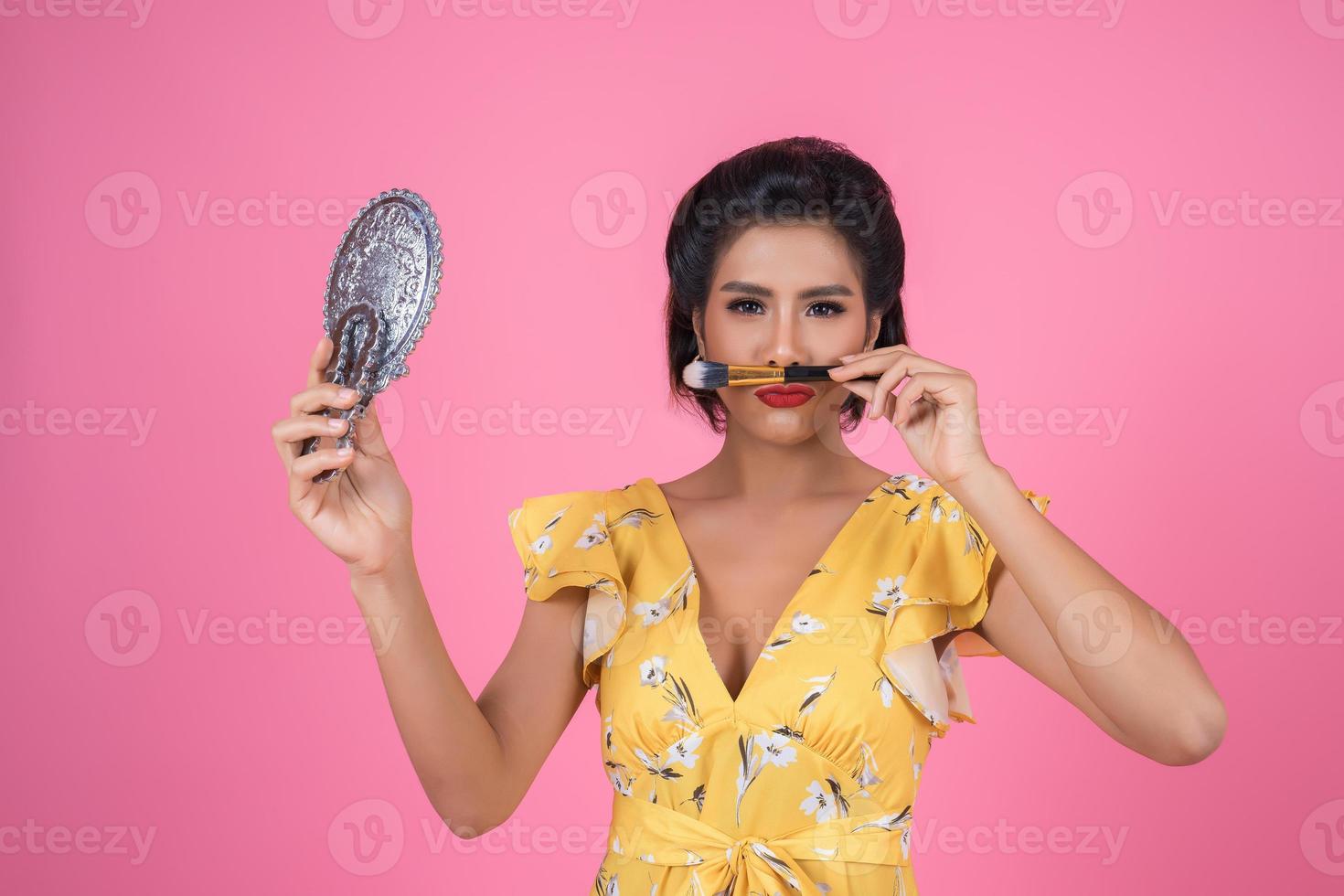 Fashionable woman with makeup and mirror photo