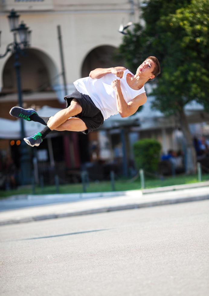 Joven realizando una voltereta en la calle foto