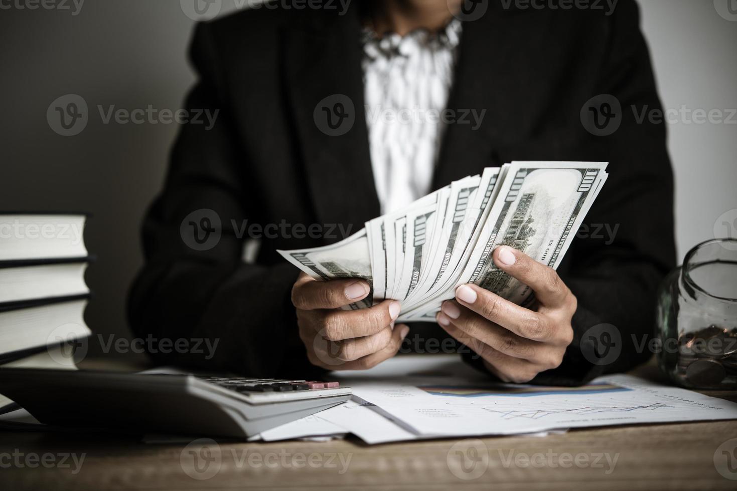 Close-up hands of a businesswoman holding dollar bills photo