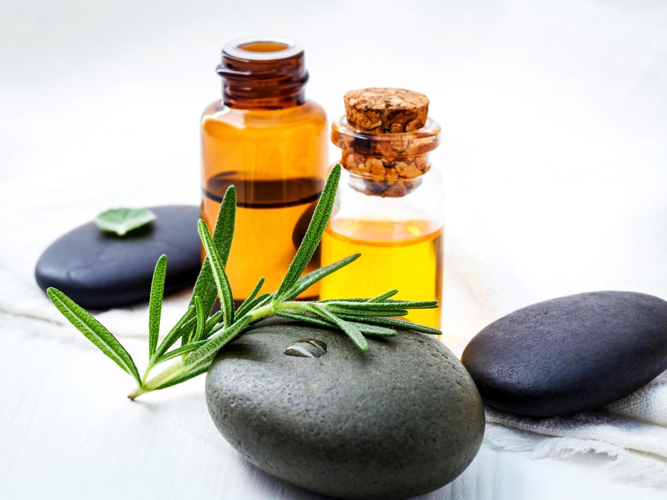 Fresh rosemary and peppermint with spa stones and essential oils photo