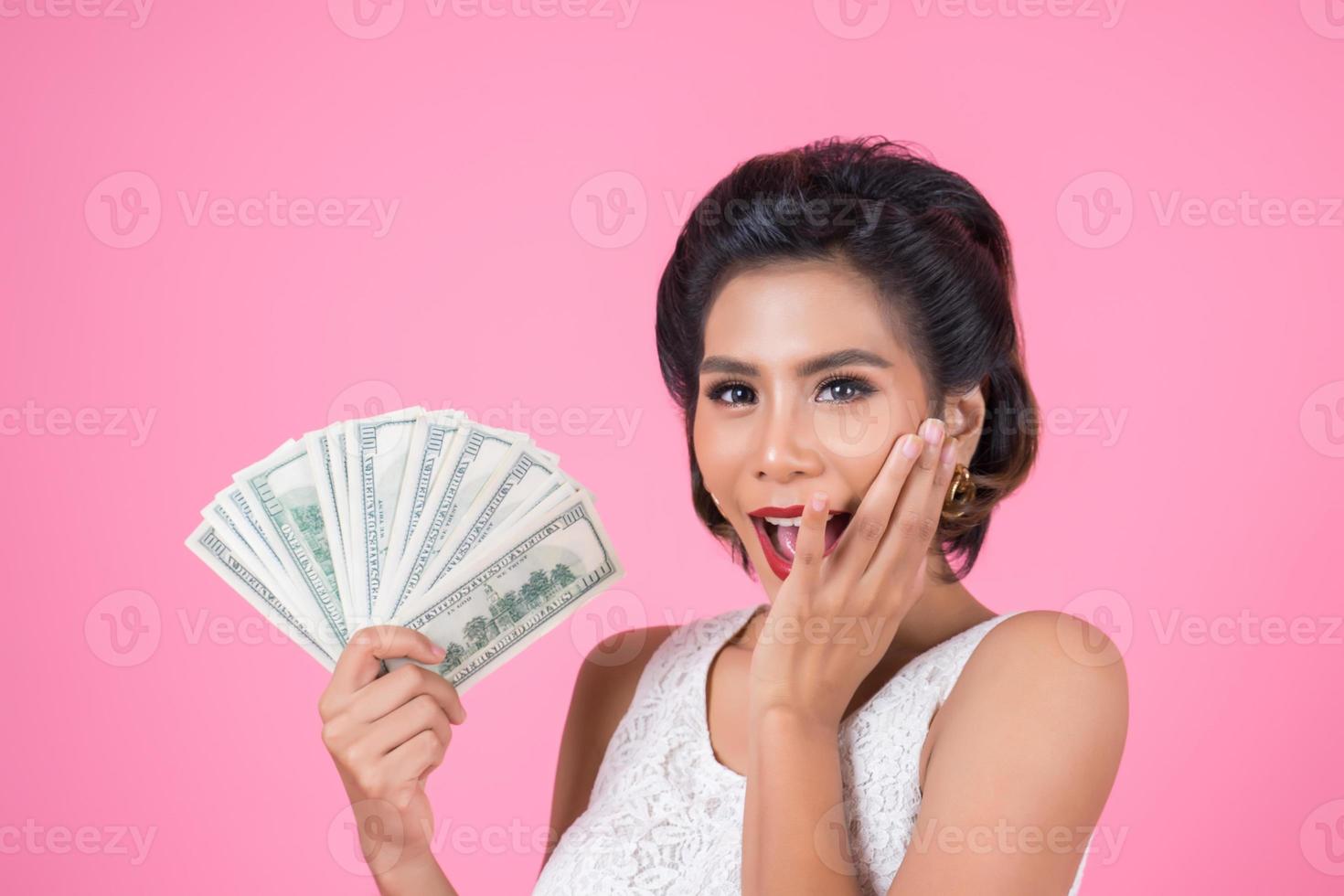 feliz hermosa mujer sosteniendo dólares foto