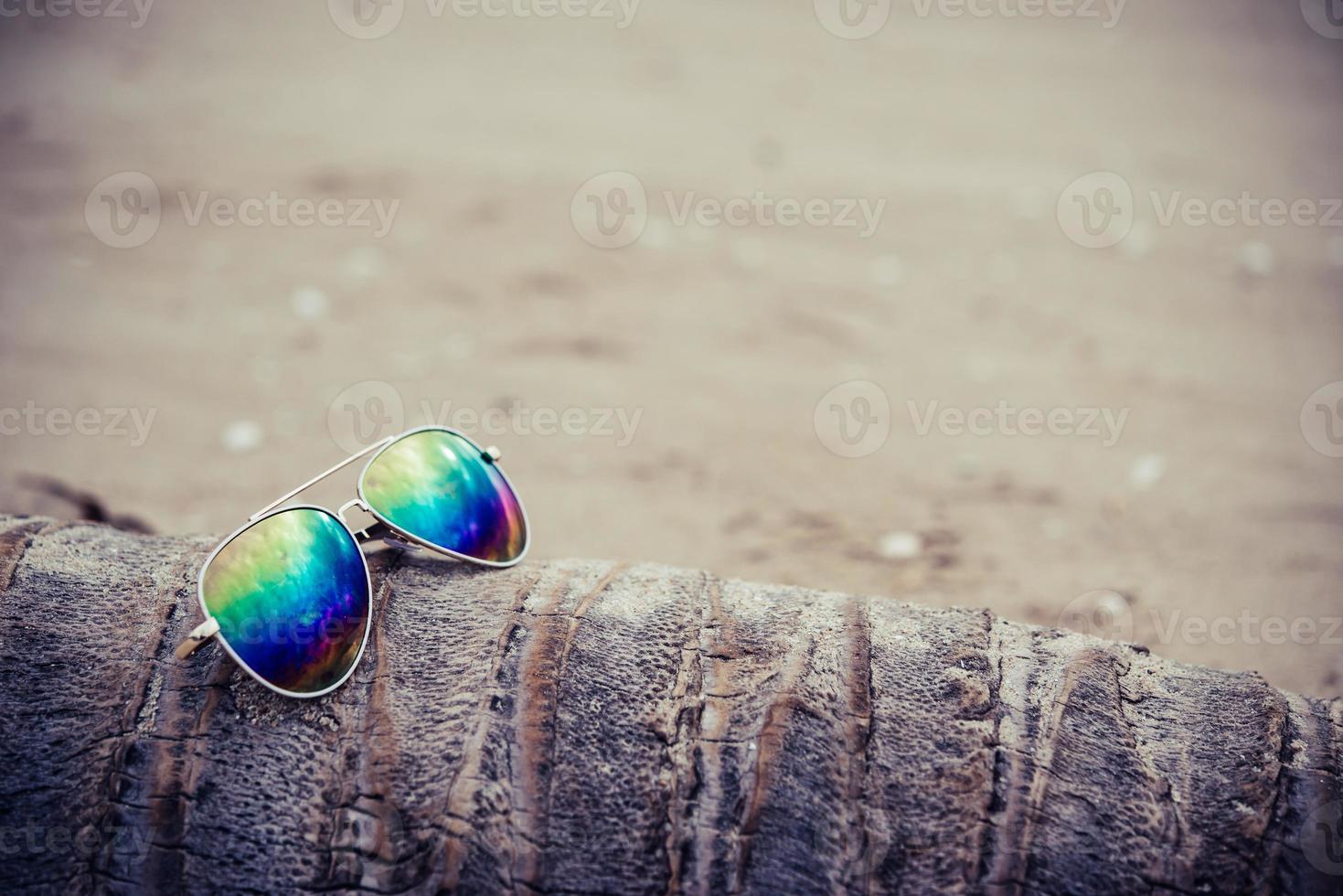 Sunglasses on the beach with a coconut tree photo