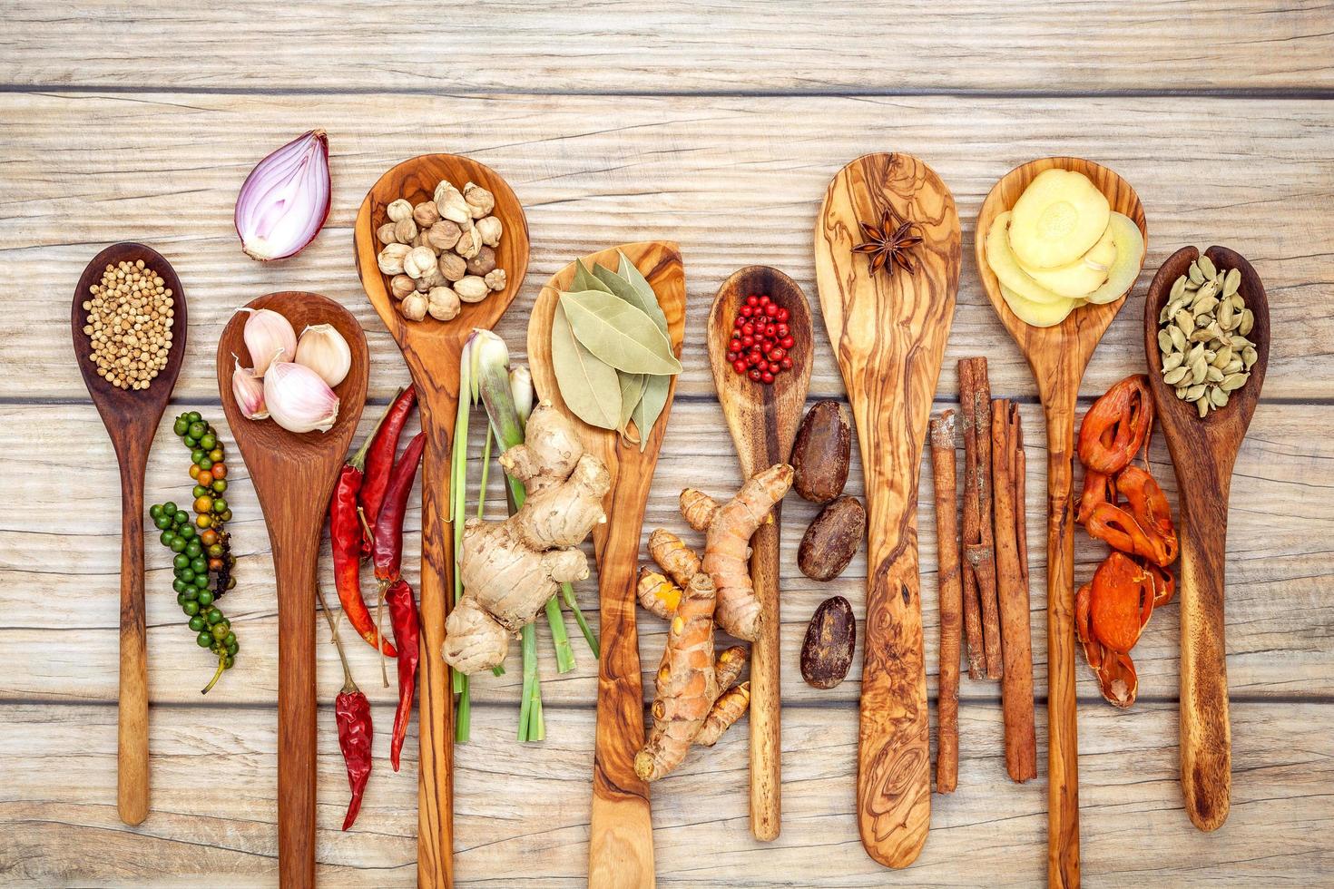 Various of spices and herbs in wooden spoons photo