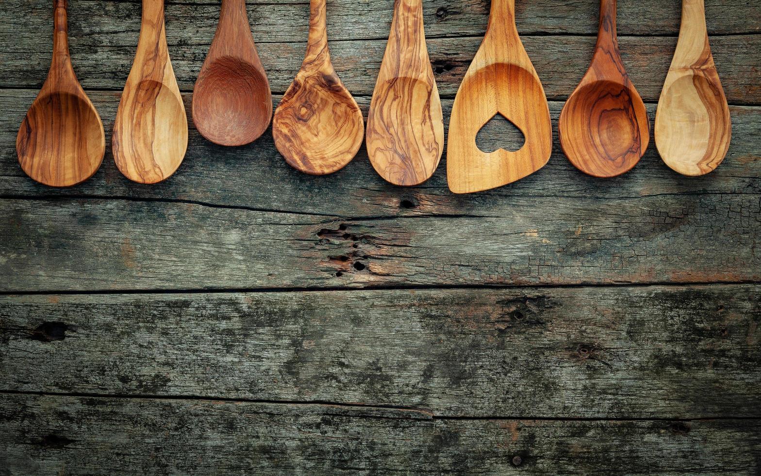 Utensilios de cocina de madera sobre fondo de madera en mal estado foto