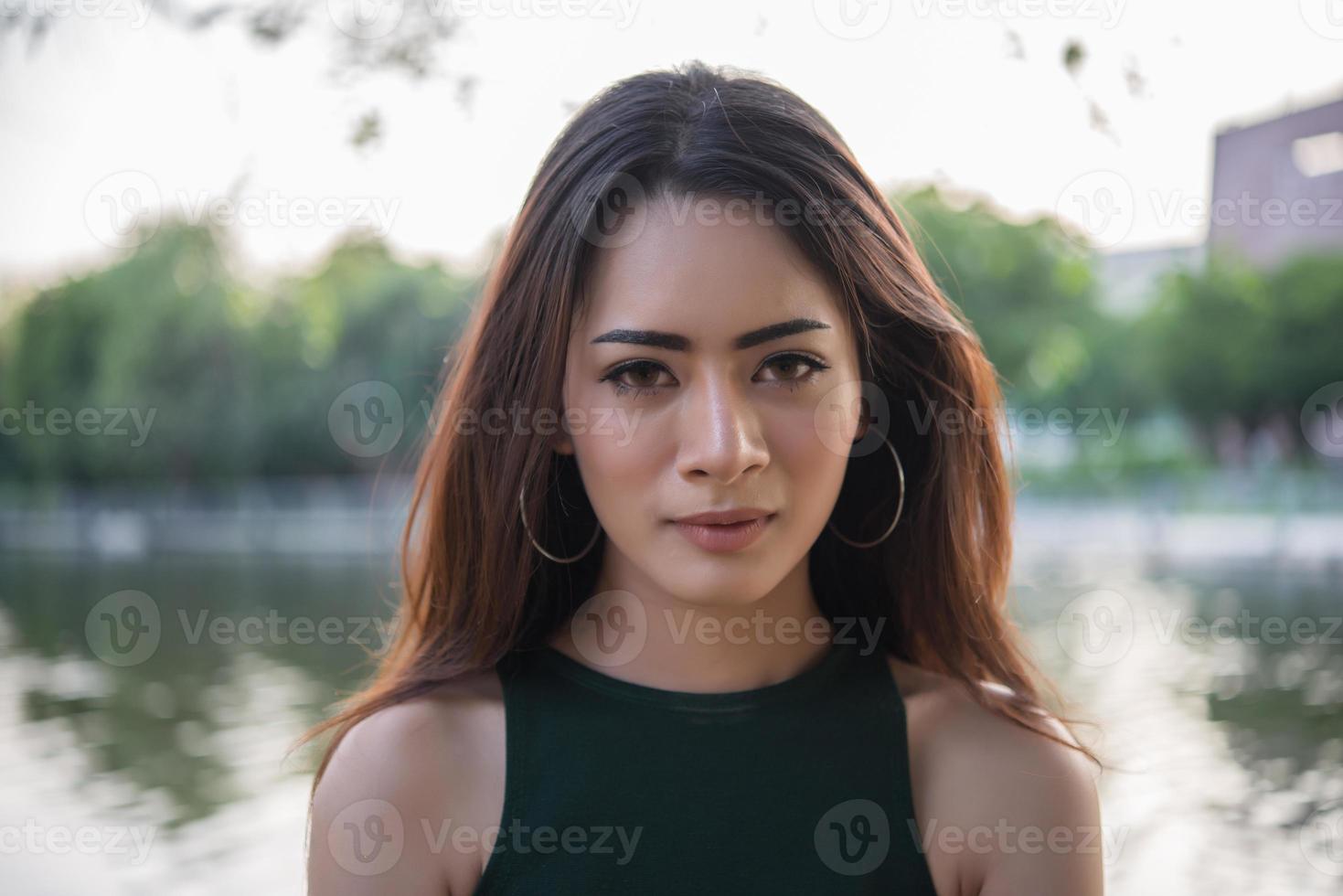 Portrait of a smiling girl relaxing in a nature park outdoors photo