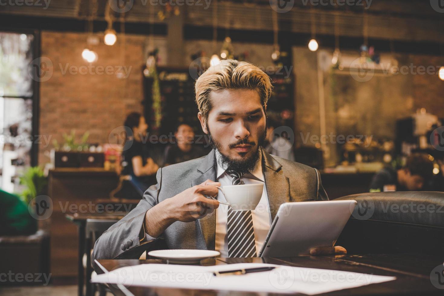 Businessman reading the newspaper and having coffee at cafe photo