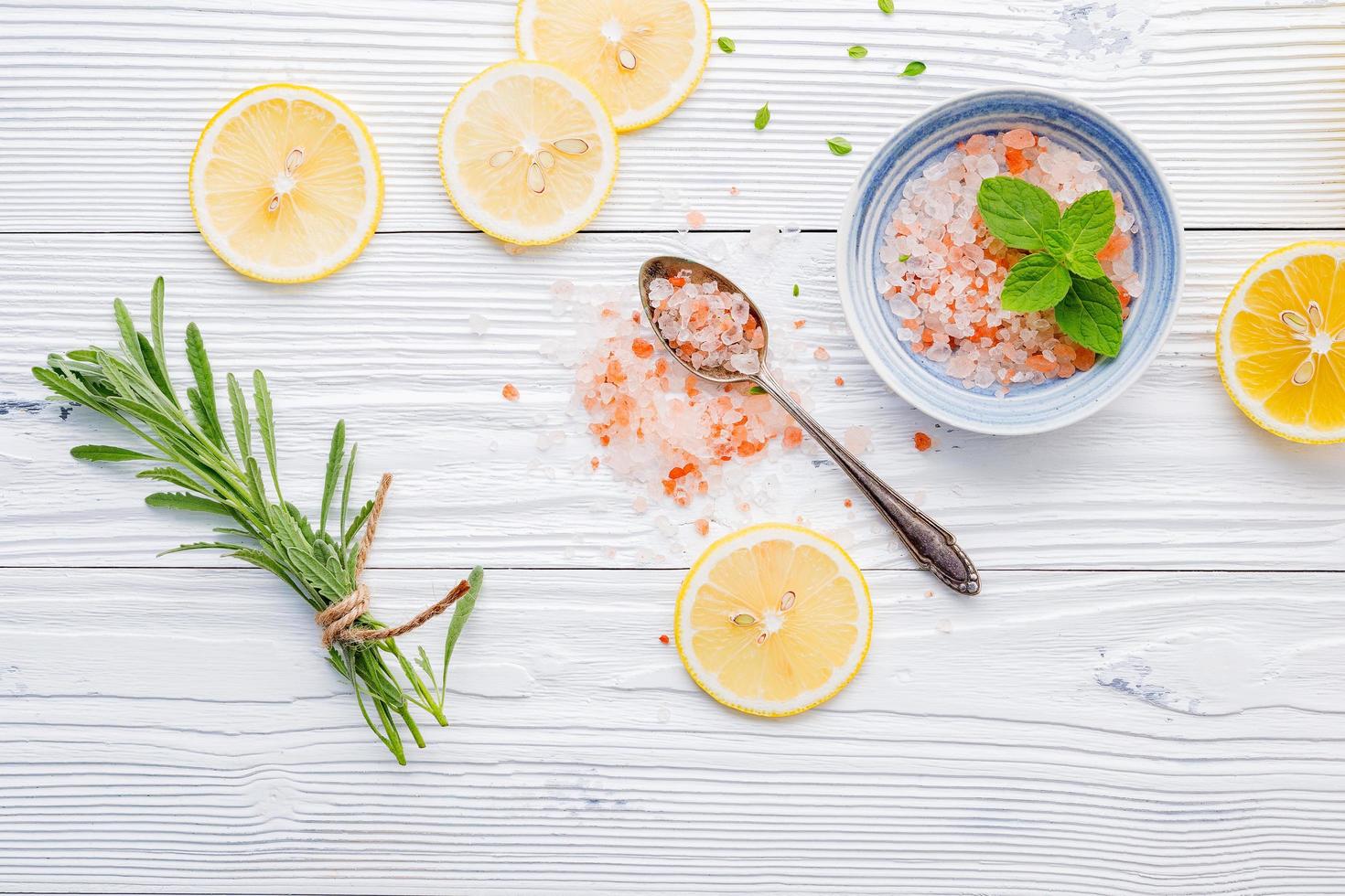 Himalayan rock salt with scented herbs on wooden background photo