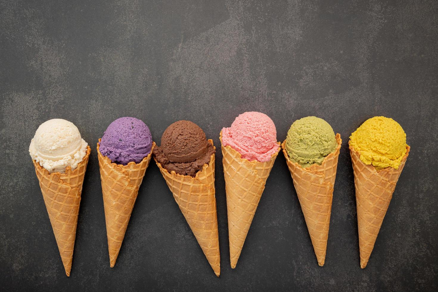 Colorful ice cream in cones on concrete photo