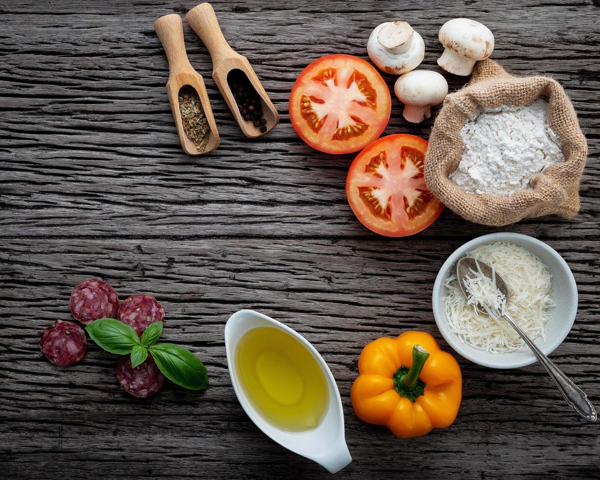 Fresh pizza ingredients on dark wood photo