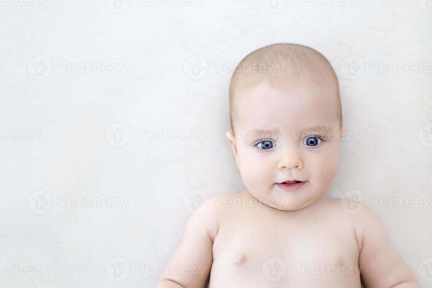 Cute baby girl lying on bed photo