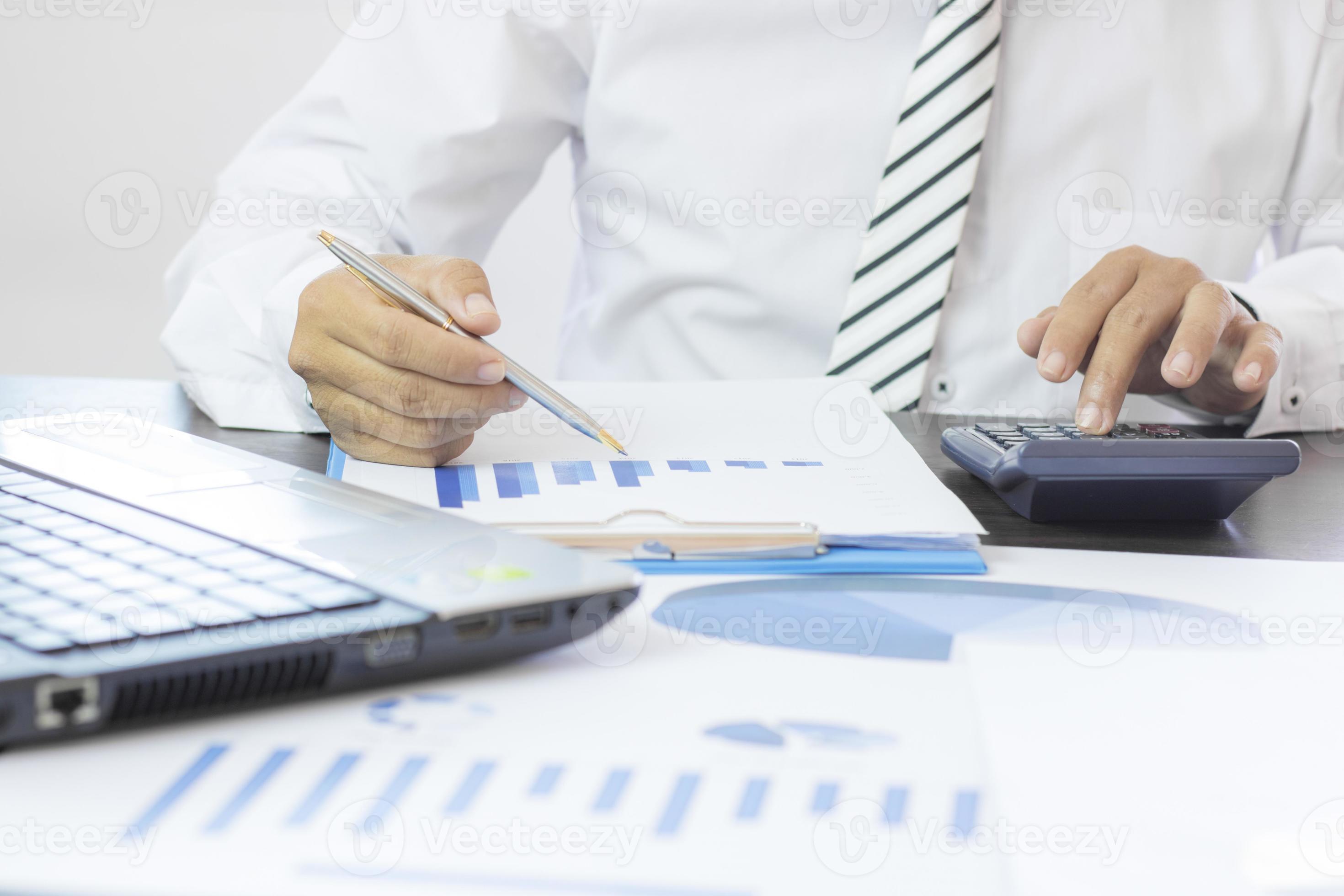 Business person working at a desk with calculator photo
