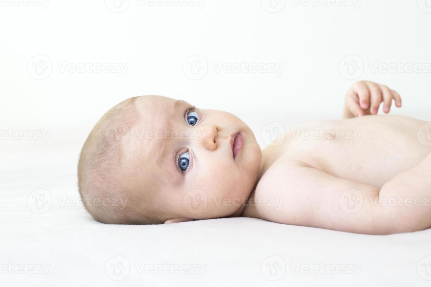 Cute baby girl lying on bed photo