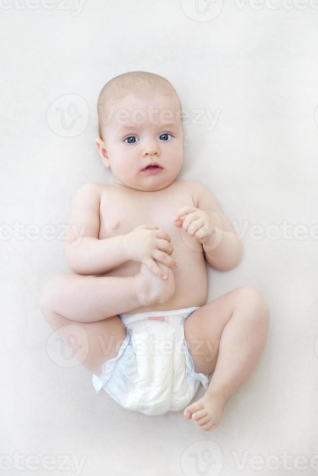 Cute baby girl lying on bed photo