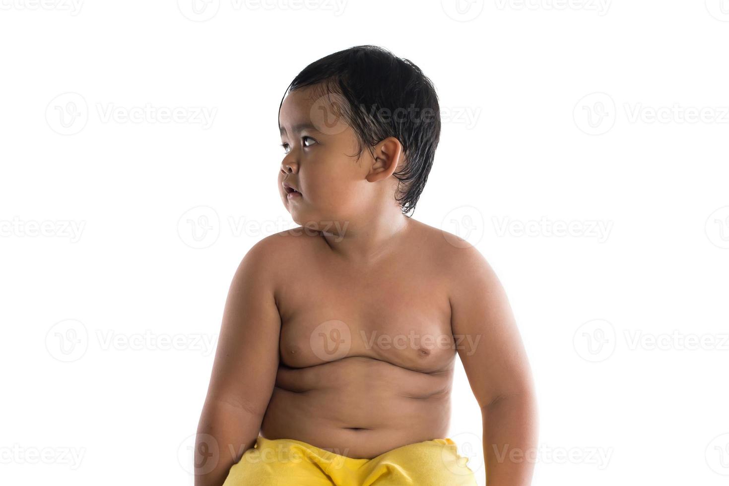 Retrato de un niño pequeño sentado aislado sobre fondo blanco. foto