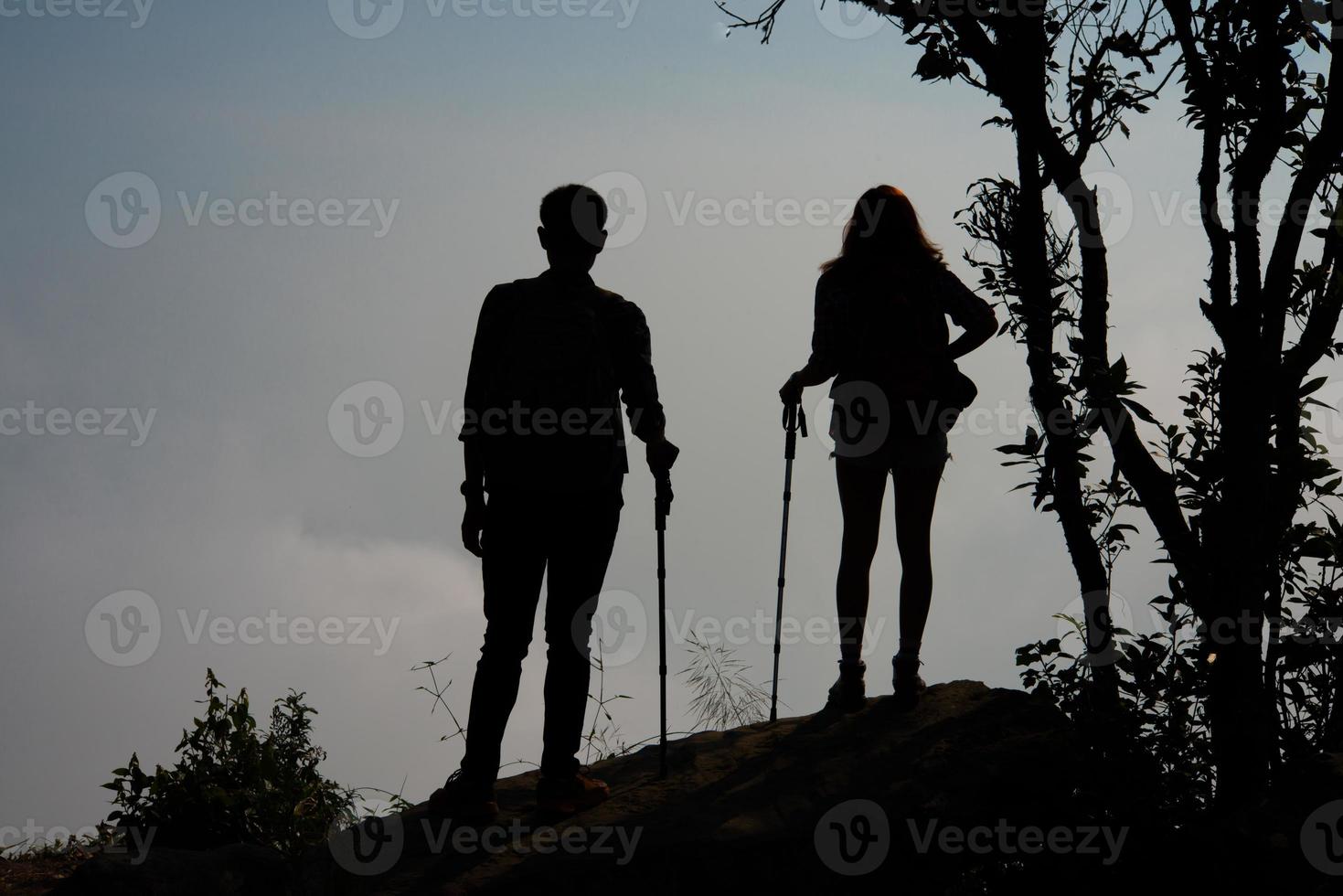 Silhouette of couple hikers on the top of a mountain photo