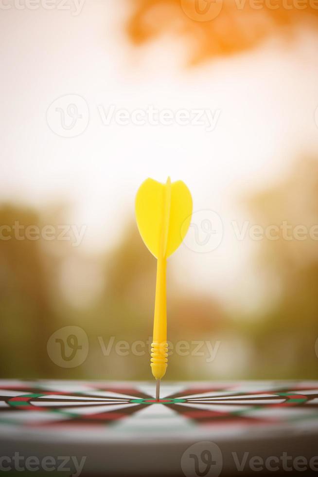 Yellow dart arrow in the center of dartboard photo