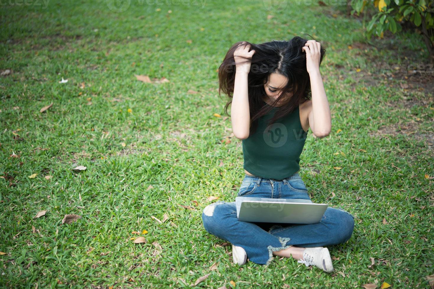 Mujer seria trabajando en un portátil al aire libre foto