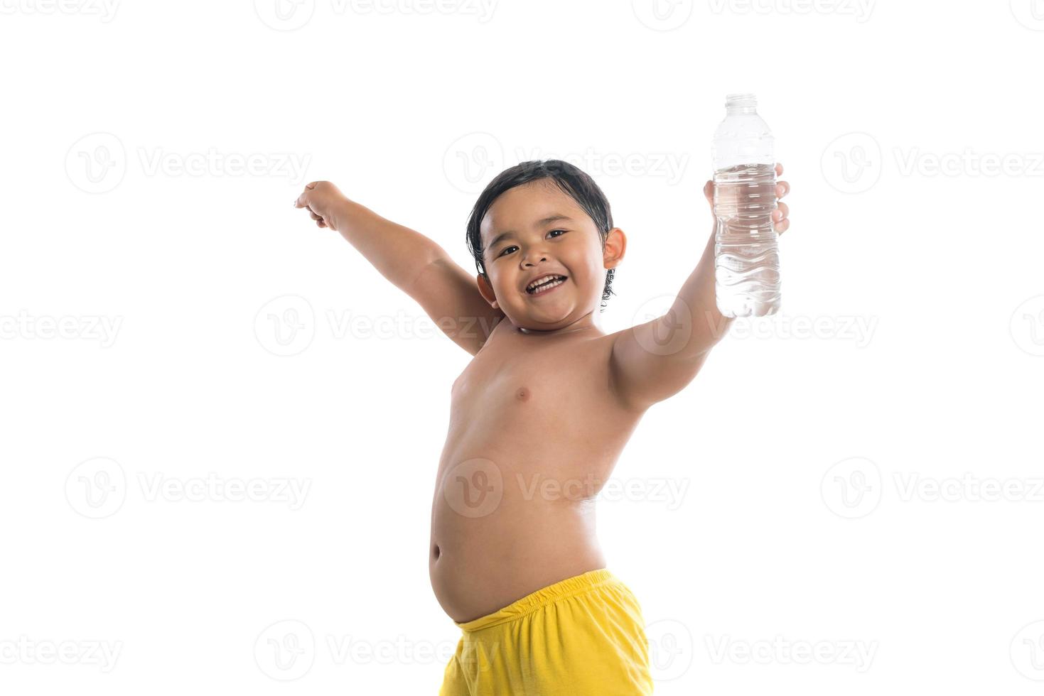 Niño feliz sosteniendo una botella de agua aislado sobre fondo blanco. foto