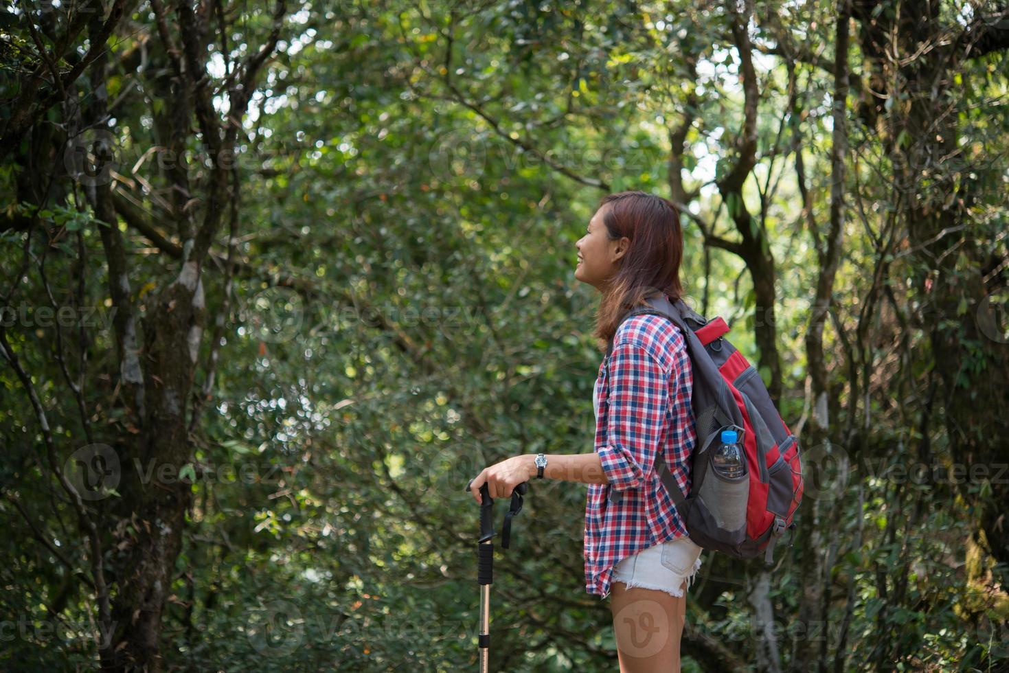 Joven excursionista mujer hipster tomando un descanso mientras camina foto