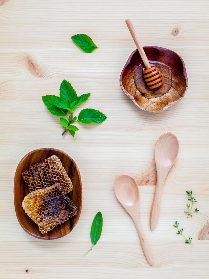 Honeycomb in wooden bowl with herbs photo