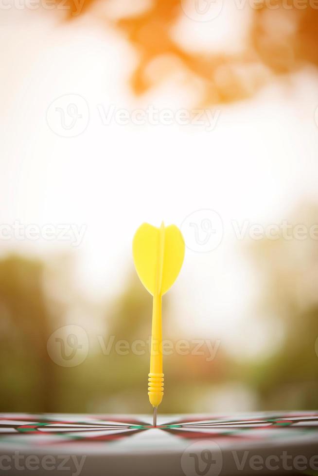 flecha de dardo amarillo en el centro del tablero de dardos foto