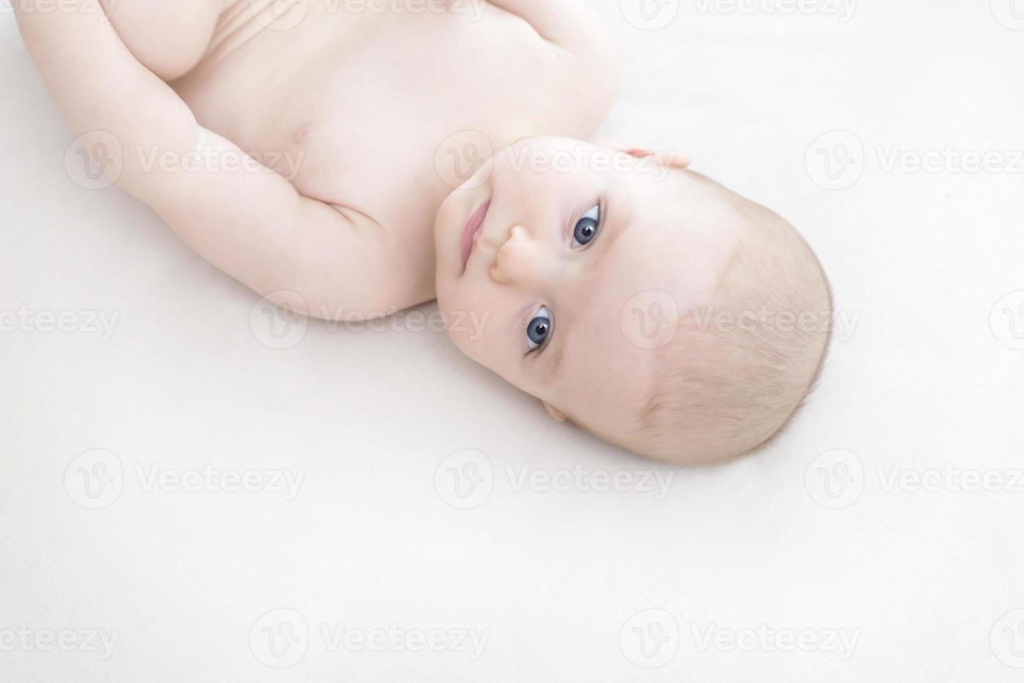 Cute baby girl lying on bed photo