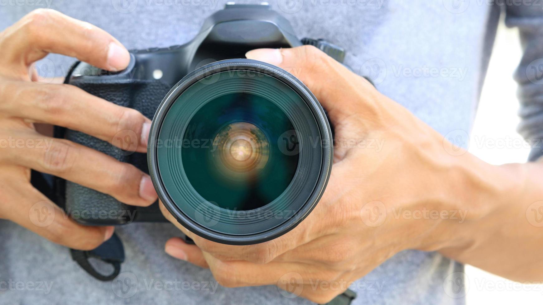 Hands holding DSLR camera photo