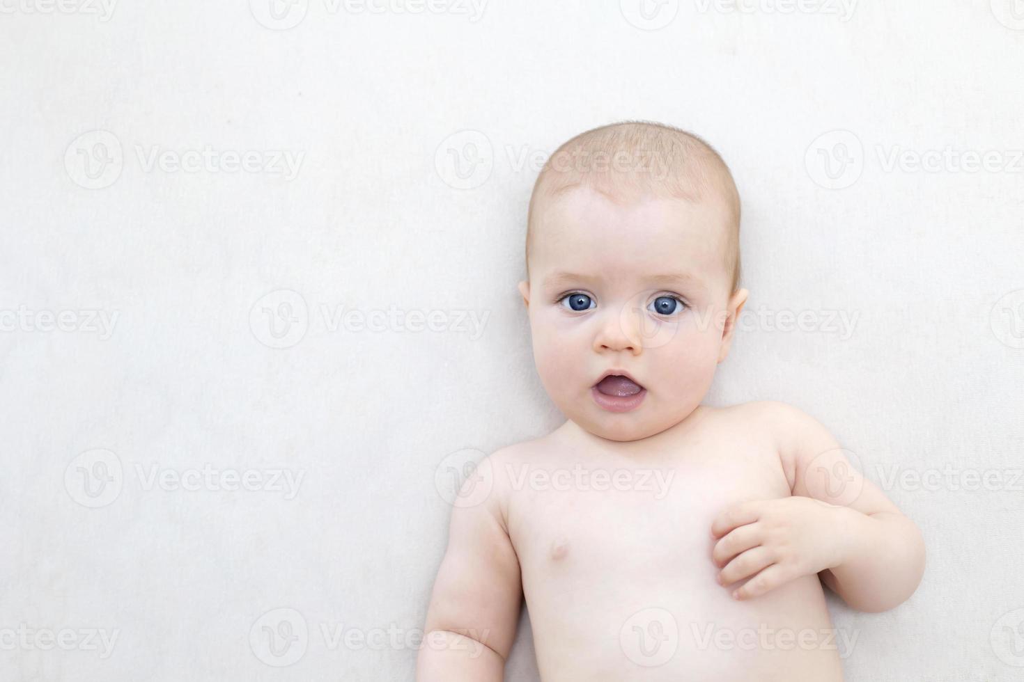 Cute baby girl lying on bed photo
