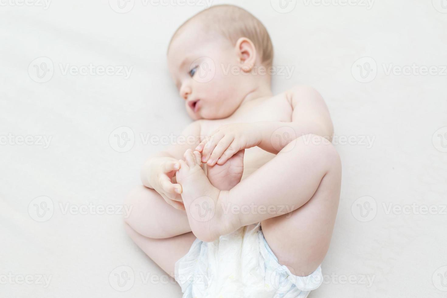 Cute baby girl lying on bed photo