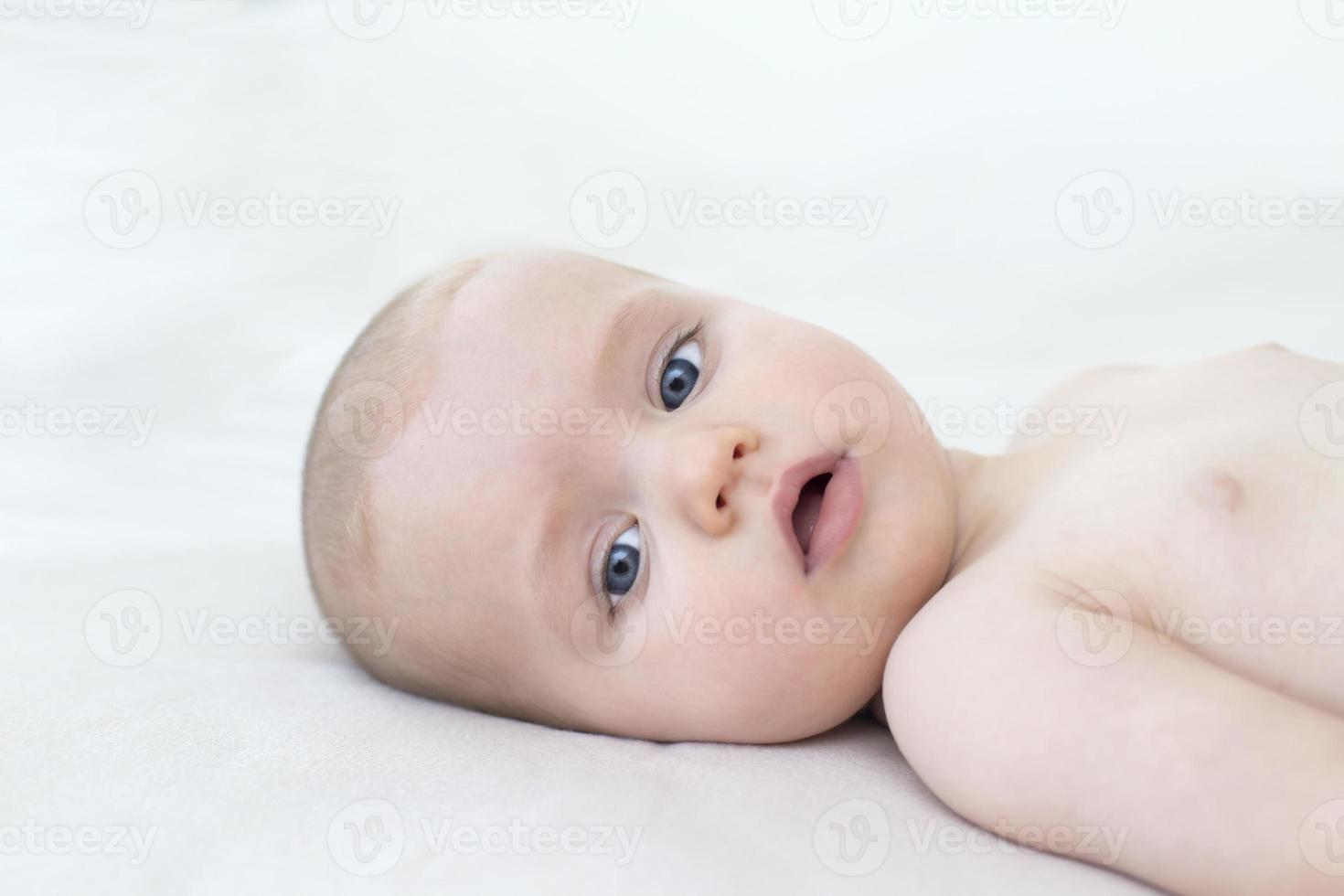 Cute baby girl lying on bed photo