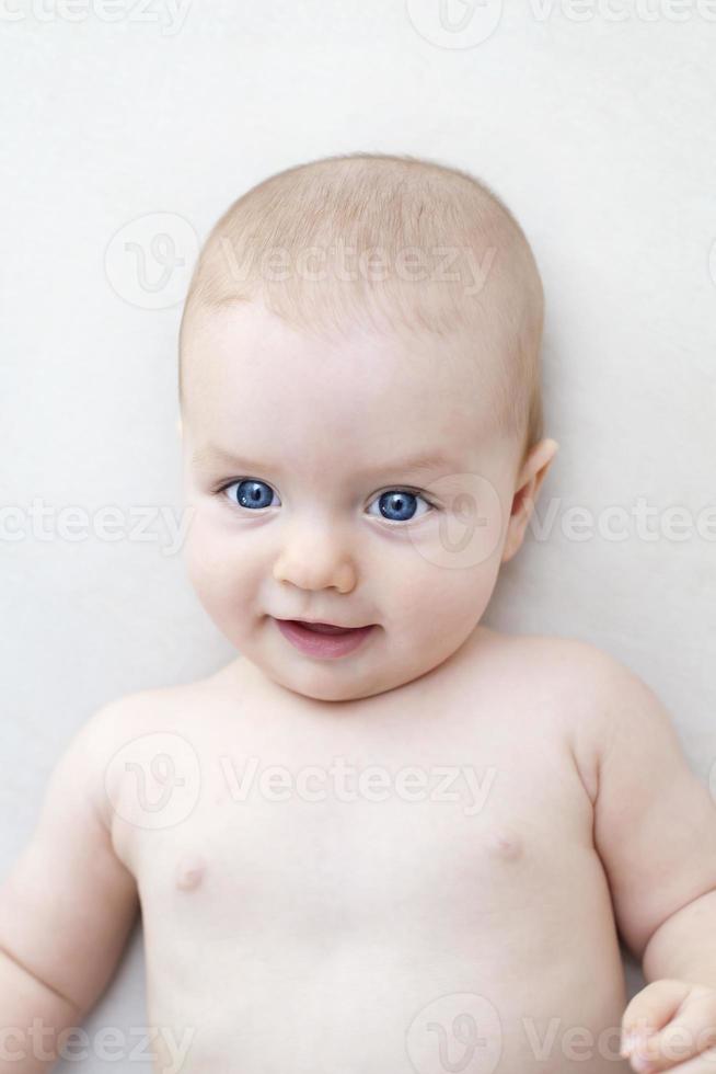 Cute baby girl lying on bed photo