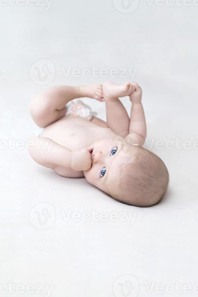 Cute baby girl lying on bed photo