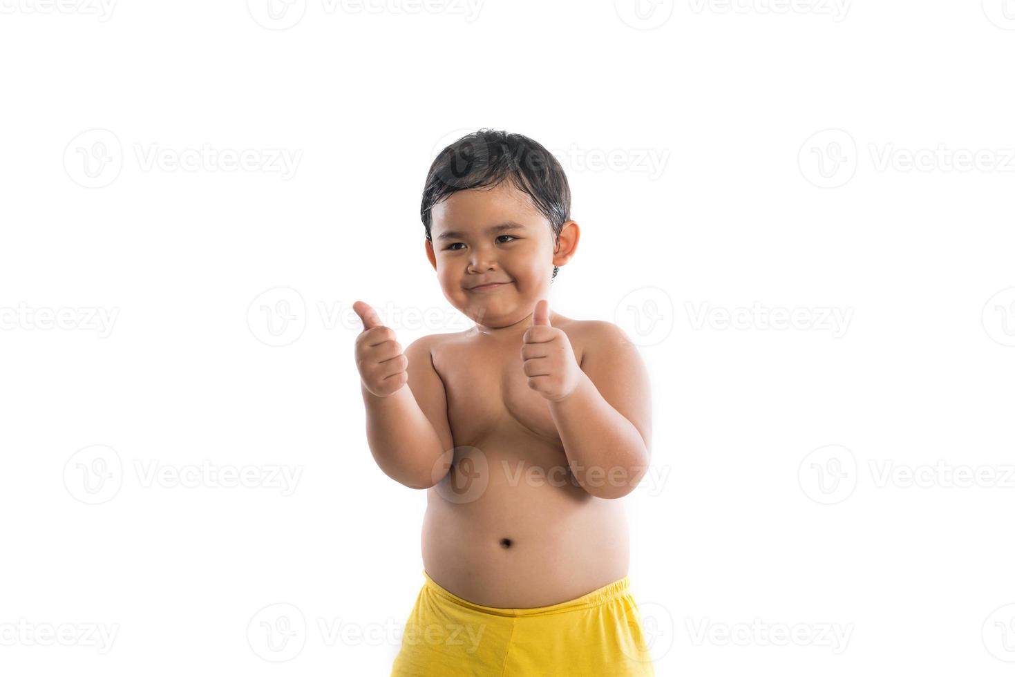 Little boy poses with thumbs up on white background photo