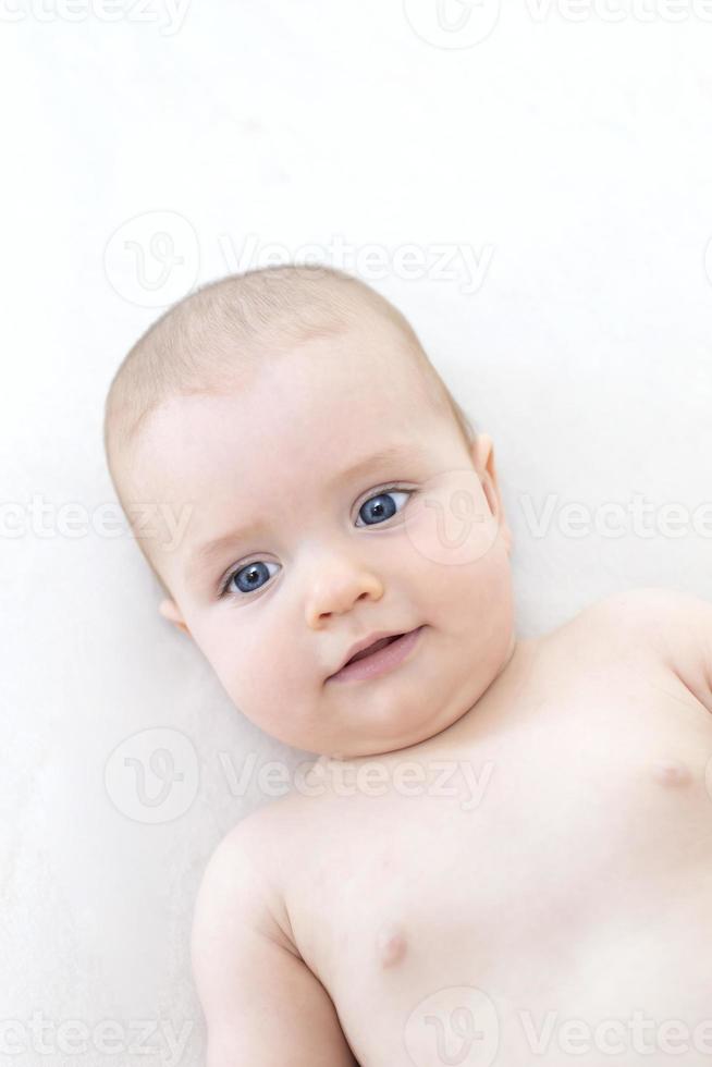 Cute baby girl lying on bed photo