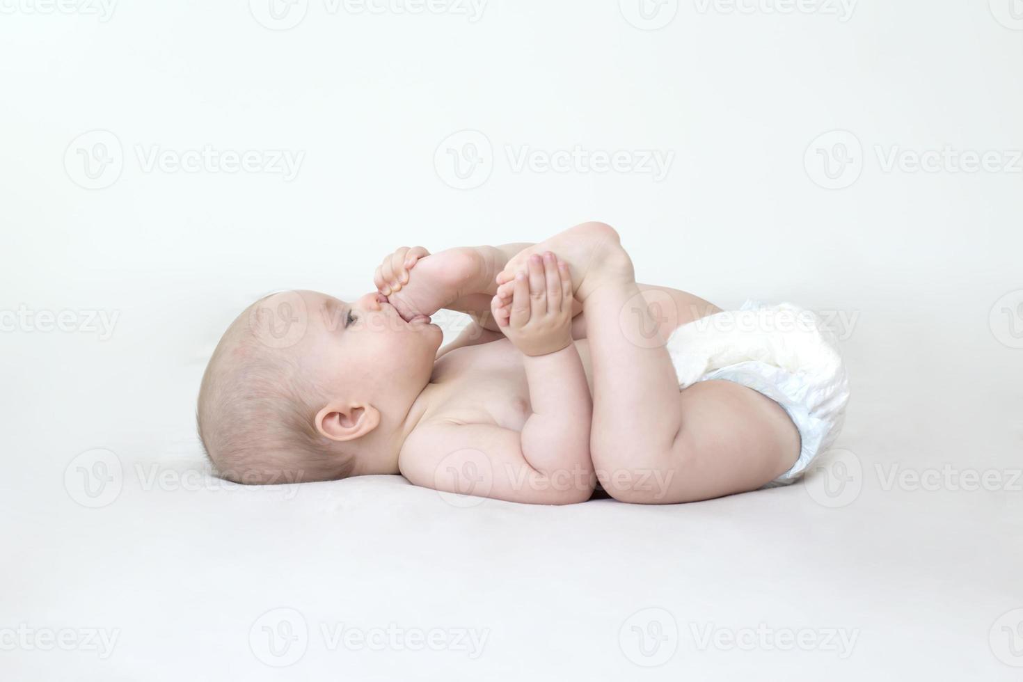 Cute baby girl lying on bed photo