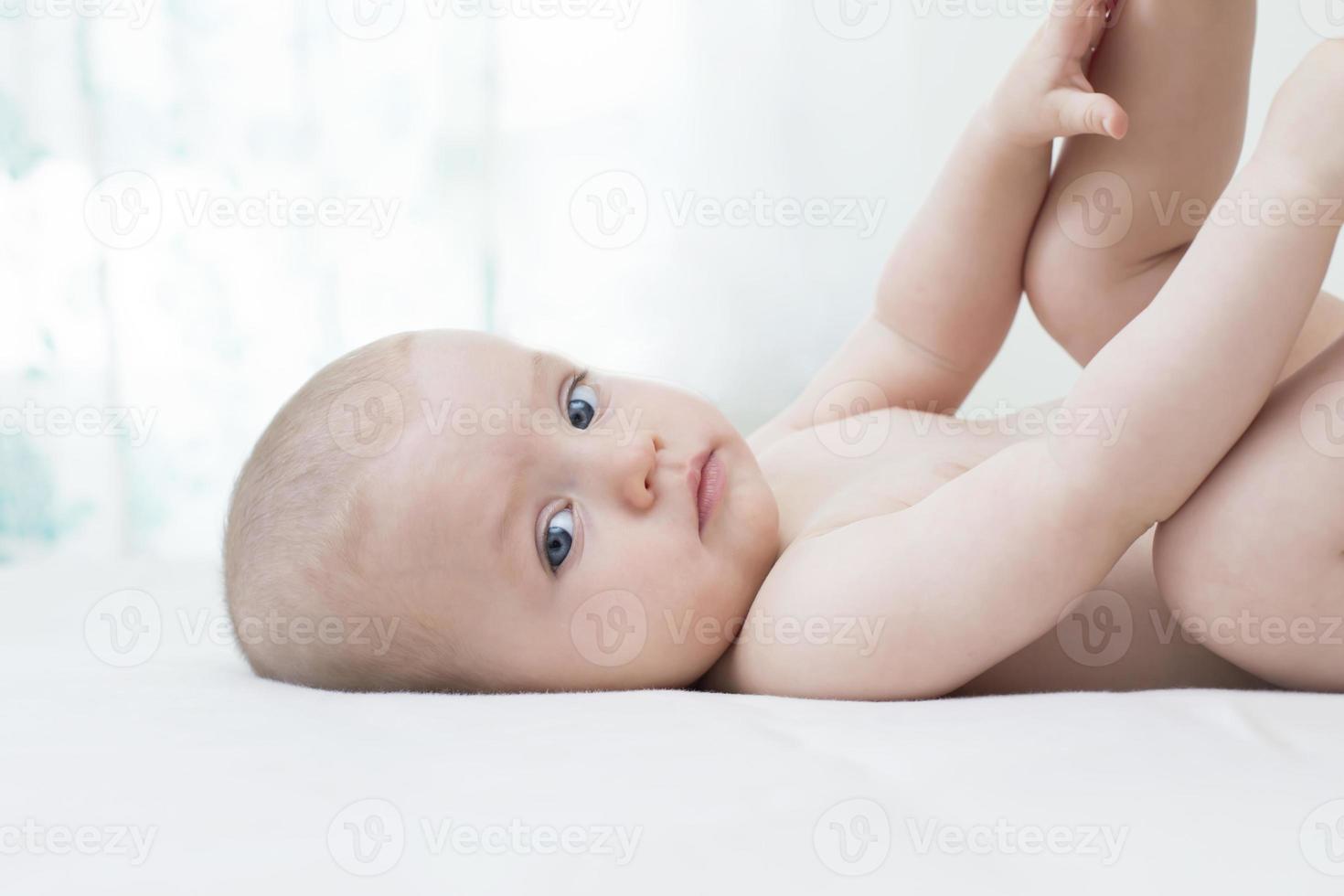 Cute baby girl lying on bed photo