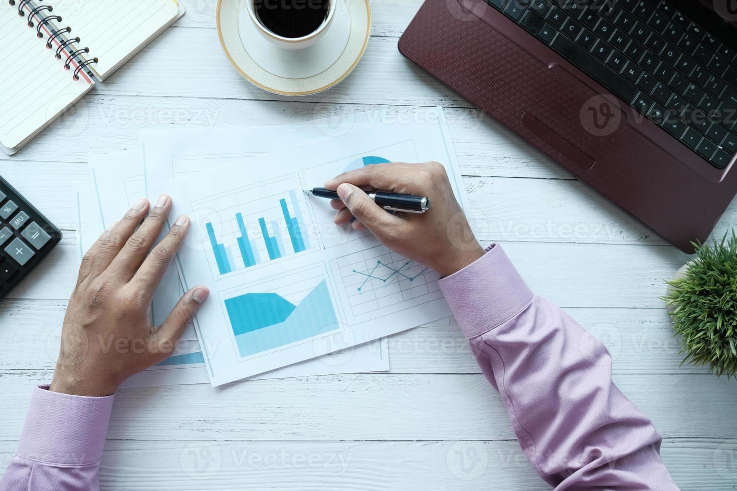 Flat composition of man's hand with pen analyzing chart on paper photo