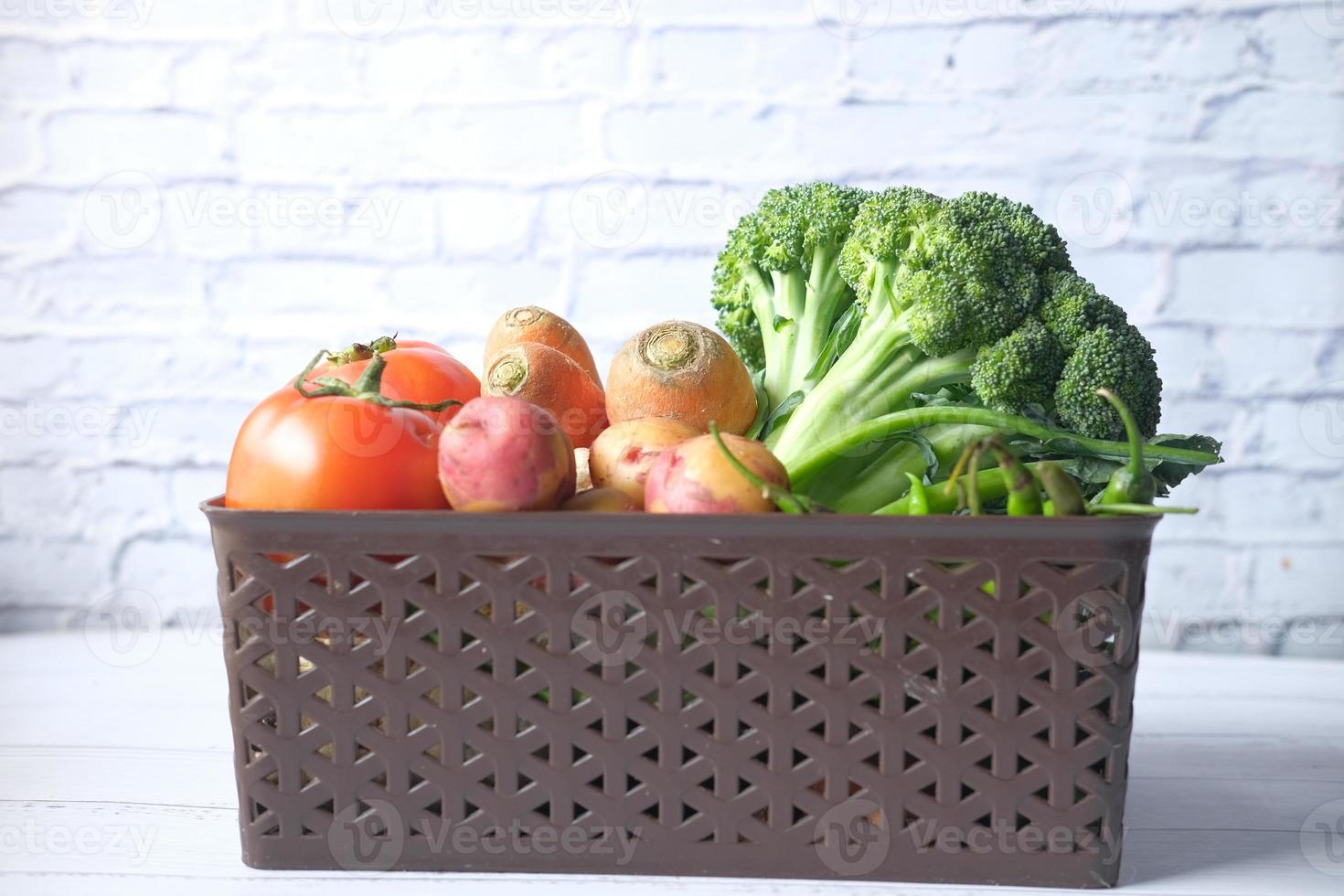 Selección de alimentos saludables con verduras frescas en un recipiente sobre la mesa foto