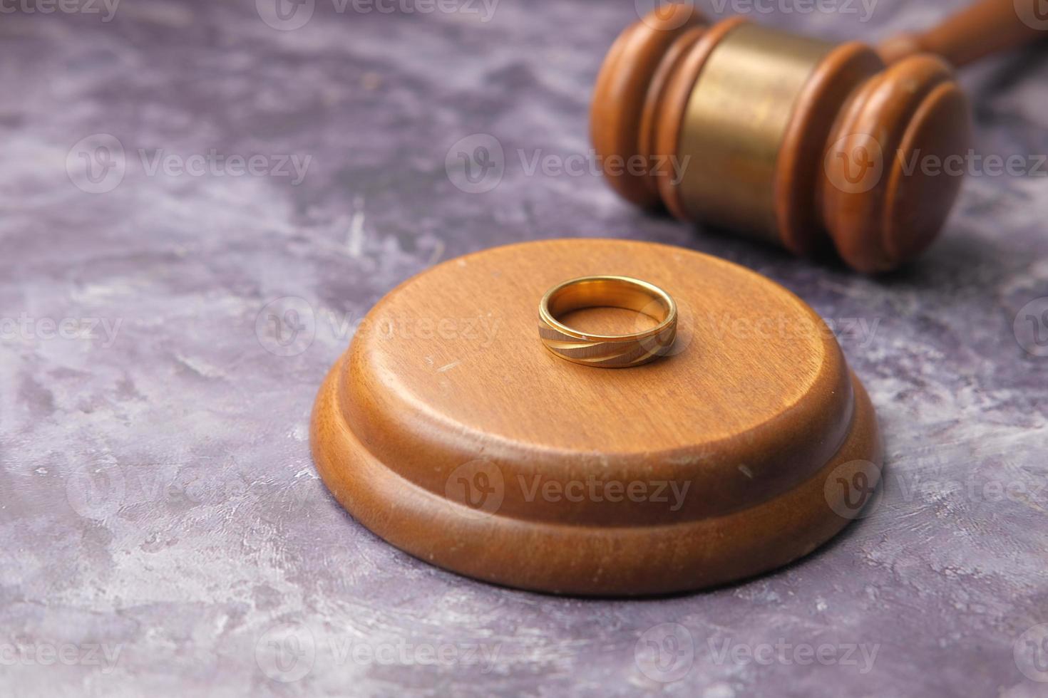 Concepto de divorcio con martillo y anillos de boda en la mesa foto