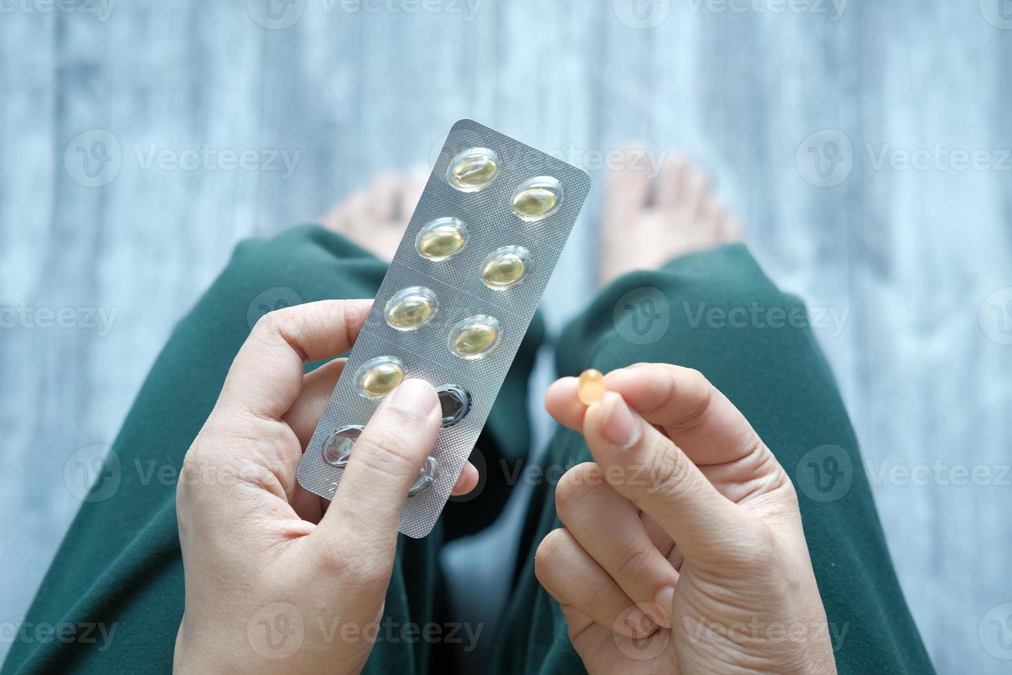 Woman holding vitamin capsules, top down view photo