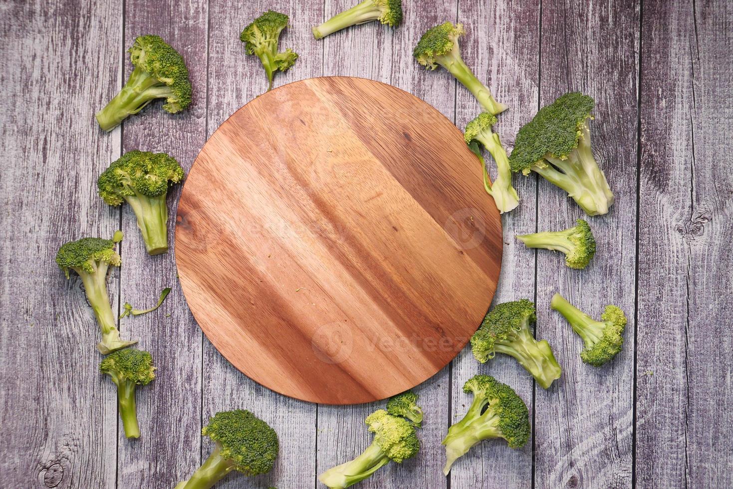 Rebanadas de brocolli y tabla de cortar en la mesa foto