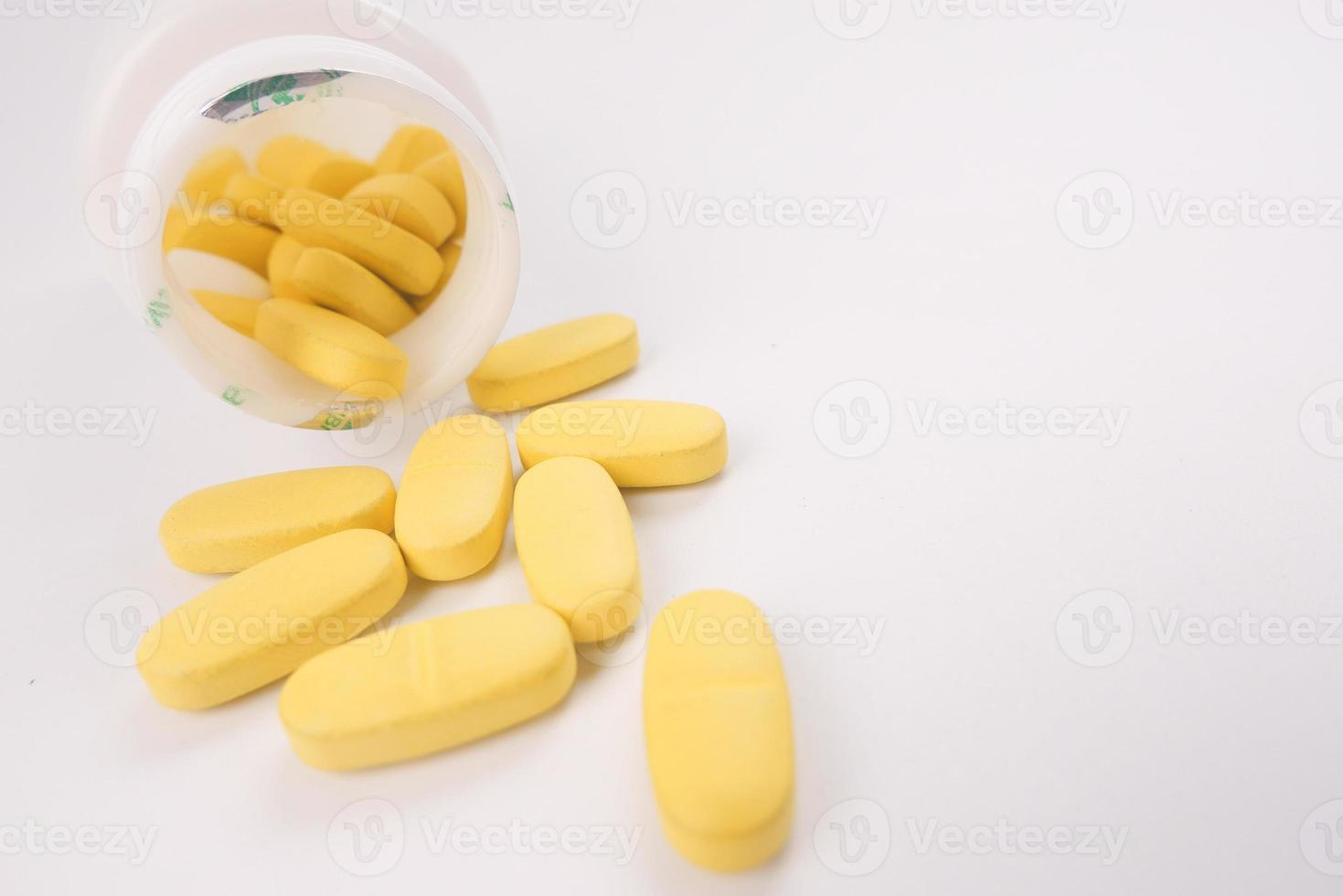 Close-up de muchas píldoras de vitaminas sobre fondo blanco. foto
