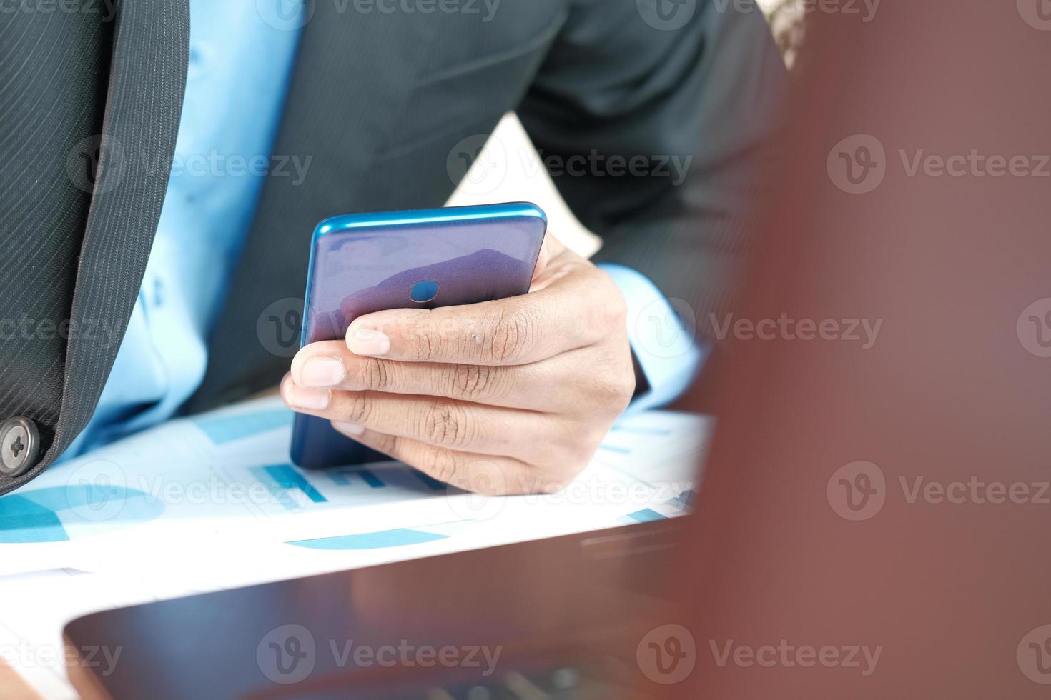 joven que trabaja en el escritorio de oficina y con smartphone foto