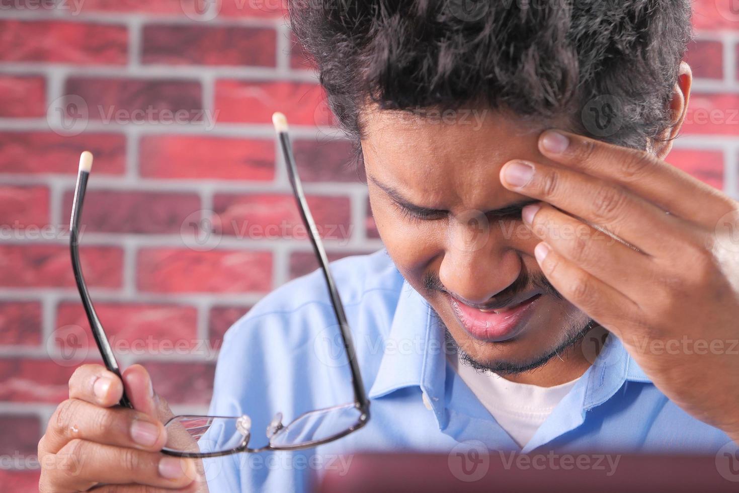 Close-up of upset man suffering from strong eye pain photo