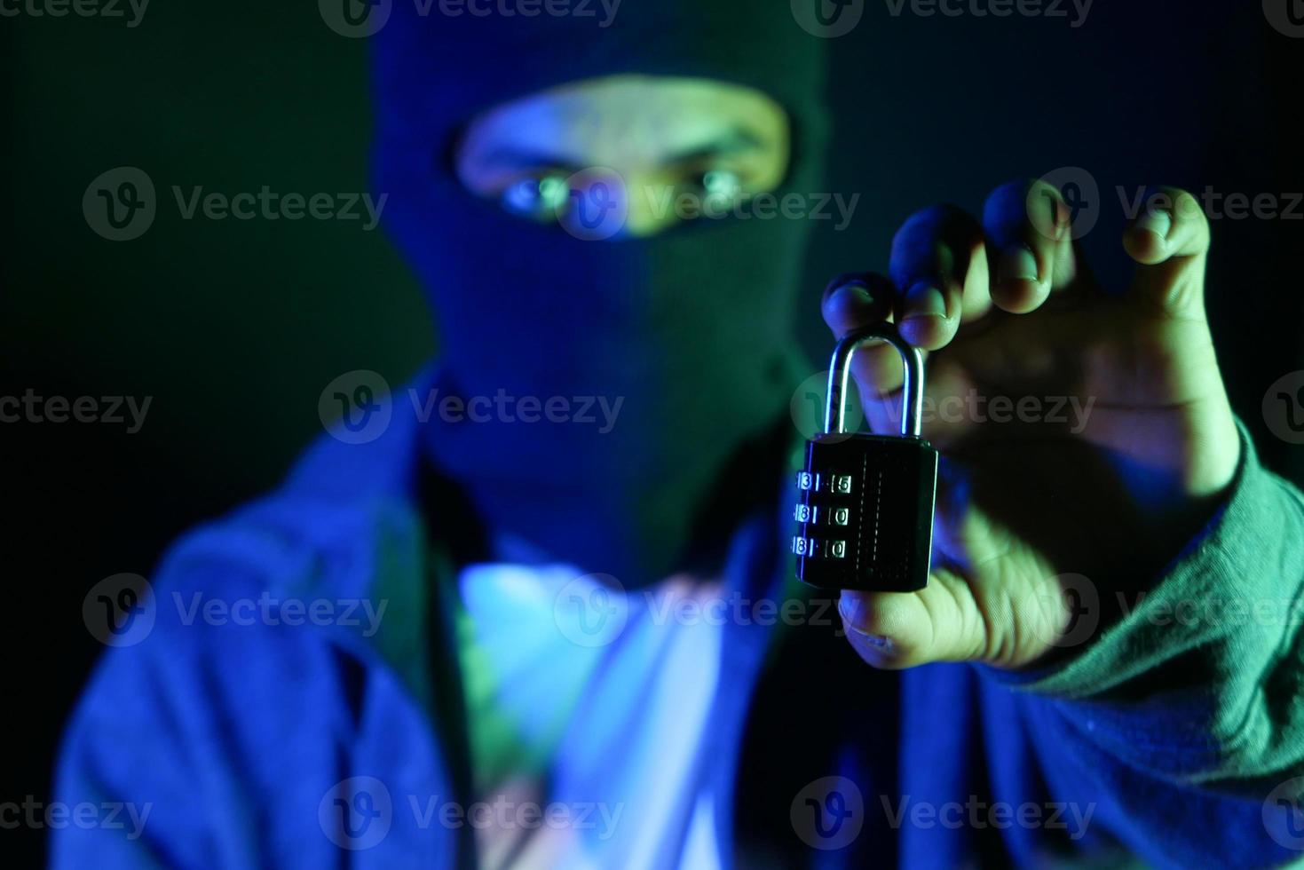 Internet safety concept with man hand holding padlock in the dark photo