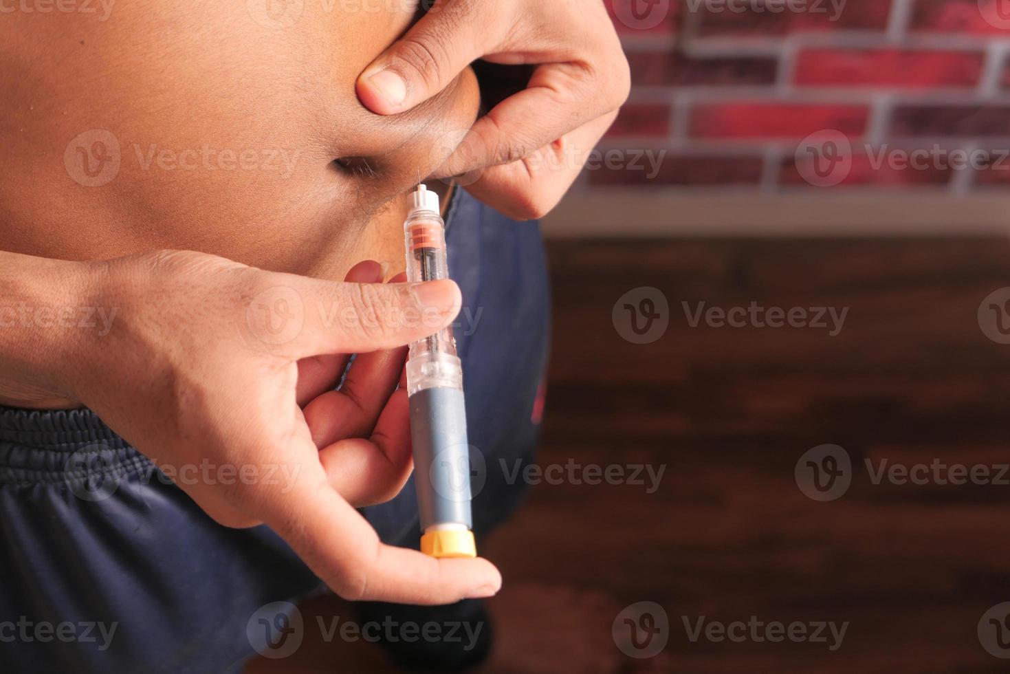 La mano del joven con primer plano de la pluma de insulina foto