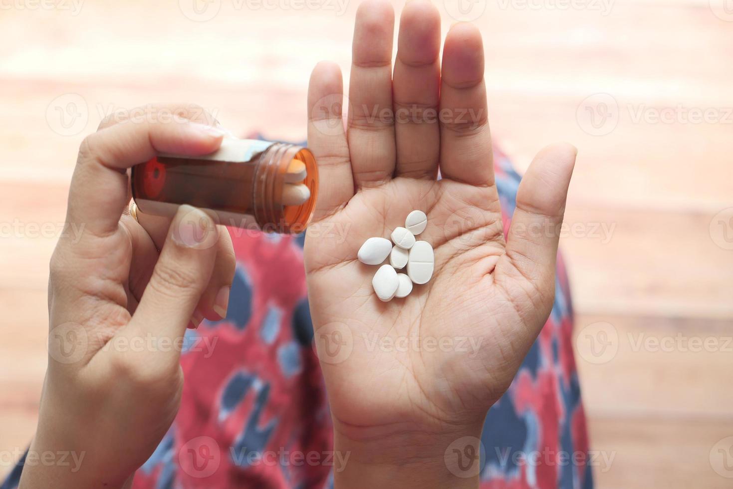 Primer plano de la mano de la mujer tomando pastillas foto